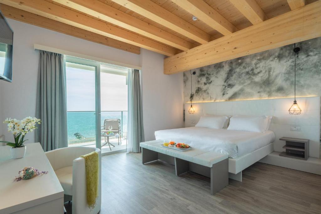 une chambre avec un lit et une vue sur l'océan dans l'établissement Hotel Elite, à Caorle