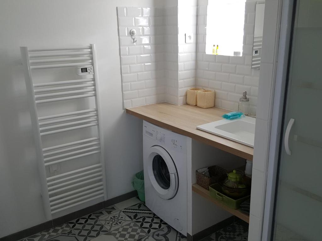 - une buanderie avec un évier et un lave-linge dans l'établissement Gîte Les "FERRAGES", à Noves