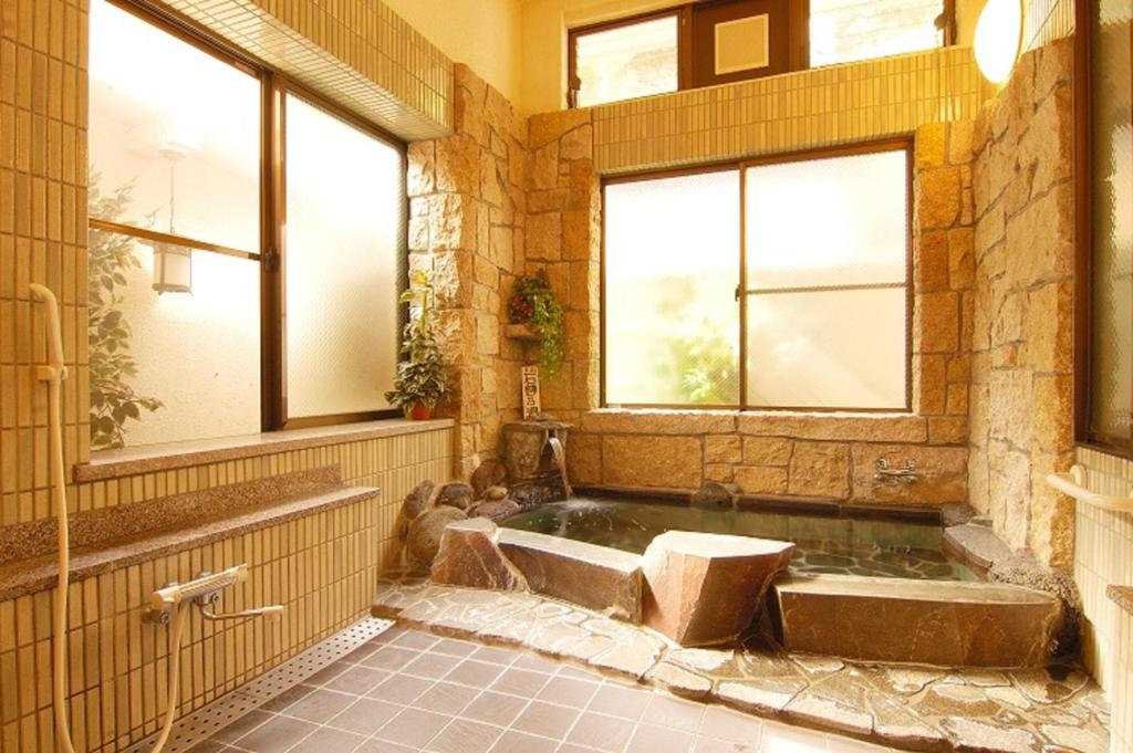 - une grande salle de bains pourvue d'une baignoire et de fenêtres dans l'établissement Sansou Nagisa, à Isehara