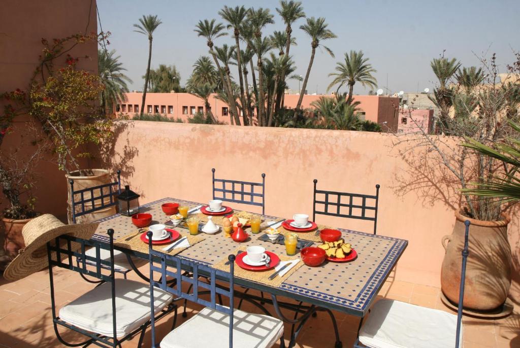 - une table bleue avec de la nourriture sur la terrasse dans l'établissement Riad Spa Dar Nimbus, à Marrakech