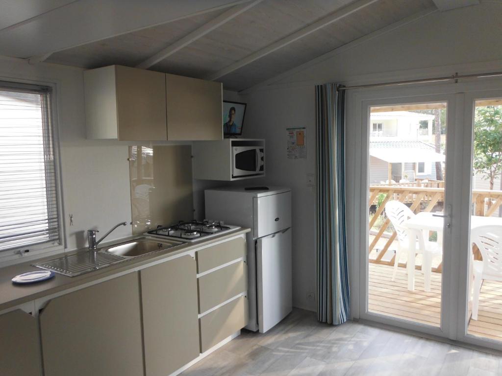 une cuisine avec un évier et une cuisinière four supérieur dans l'établissement Camping l'Eléphant, à Saint-Raphaël