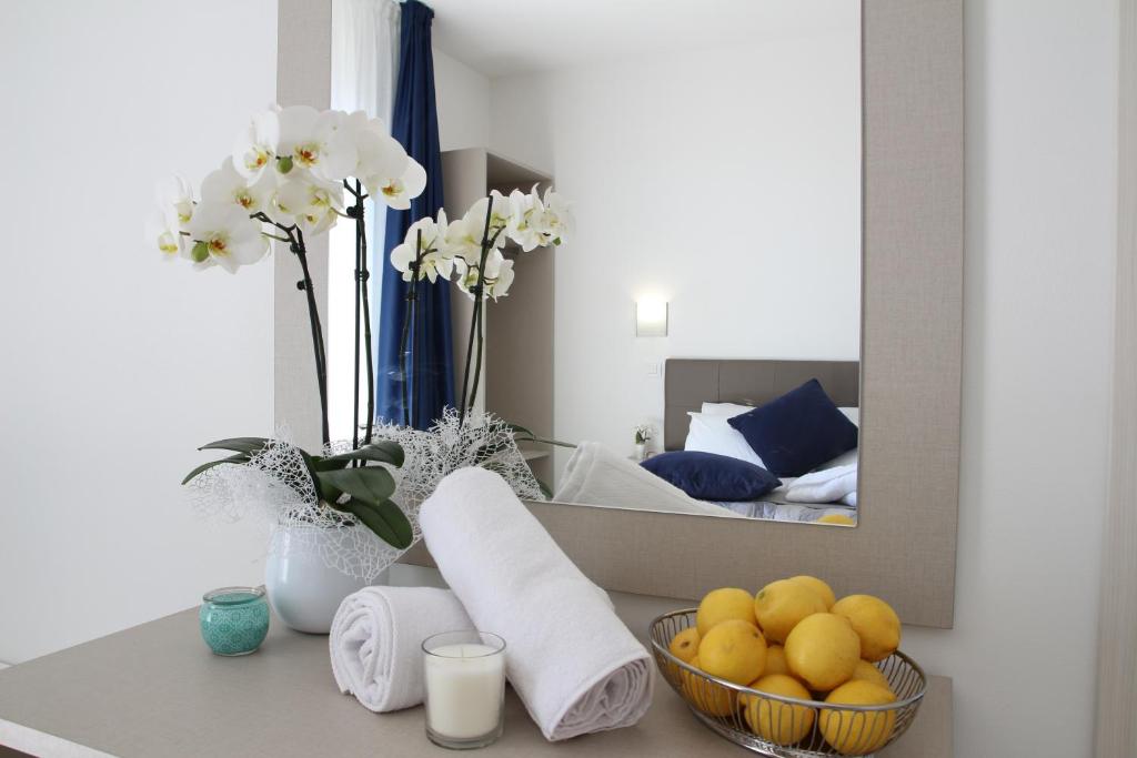 - un comptoir de salle de bains avec un miroir et une corbeille de fruits dans l'établissement Hotel Arena, à Lido di Jesolo