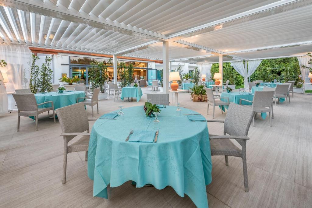 une salle à manger avec des tables et des chaises bleues dans l'établissement Acacia Marina, à Marina di Ragusa