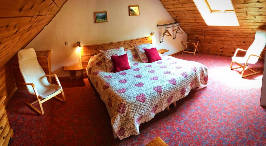 une chambre avec un grand lit et deux chaises dans l'établissement Hôtel & Spa La Ferme de l'Izoard, à Arvieux 37 autres photos