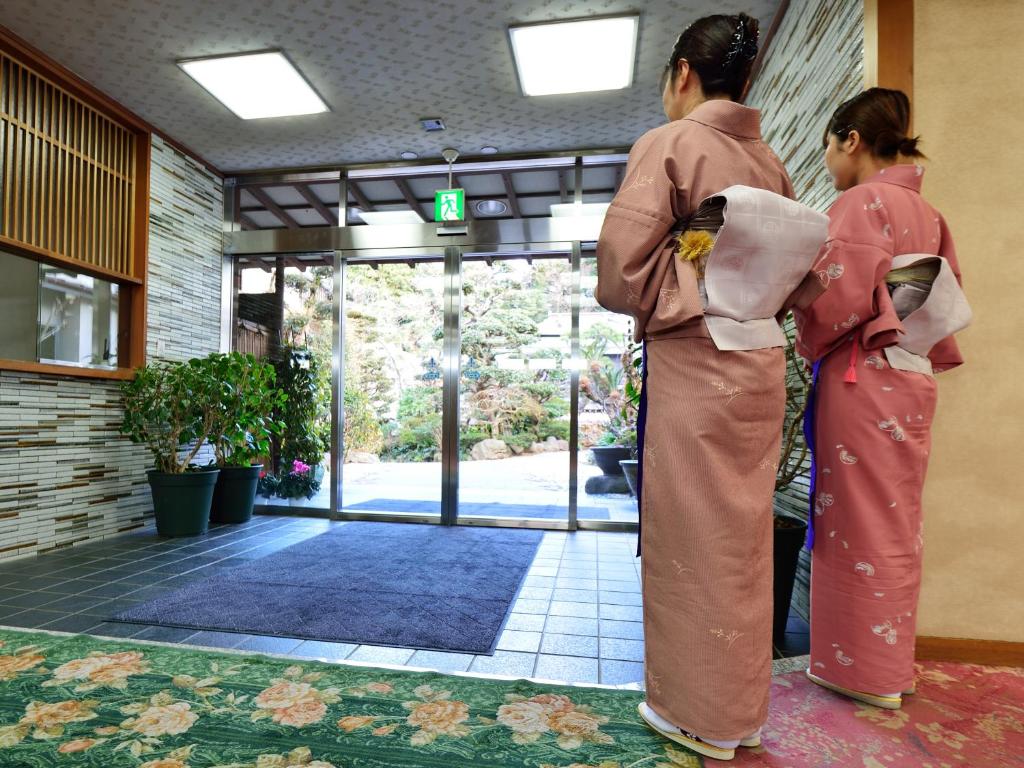 deux femmes en kimonos debout devant une porte dans l'établissement Iwamotoro, à Fujisawa 37 autres photos