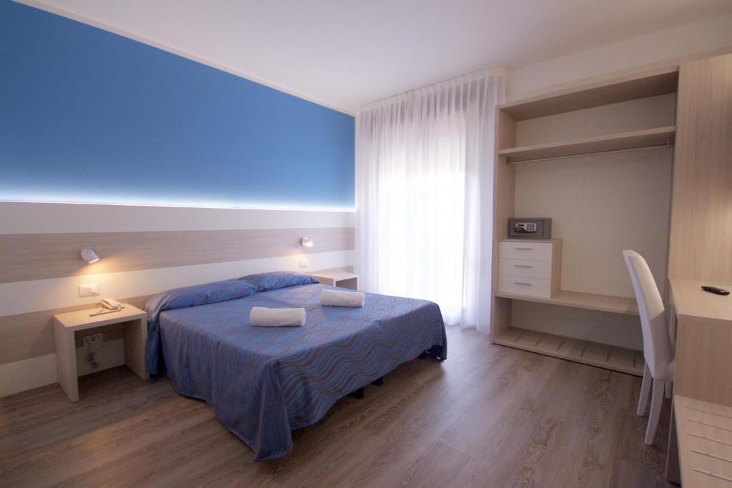 une chambre avec un lit, un bureau et une fenêtre dans l'établissement Hotel Serenella, à Lido di Jesolo