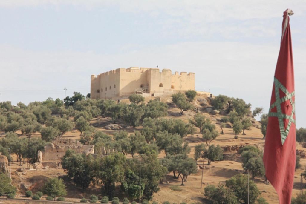 un bâtiment au sommet d'une colline avec drapeau dans l'établissement Dar Lalla Kenza, à Fès