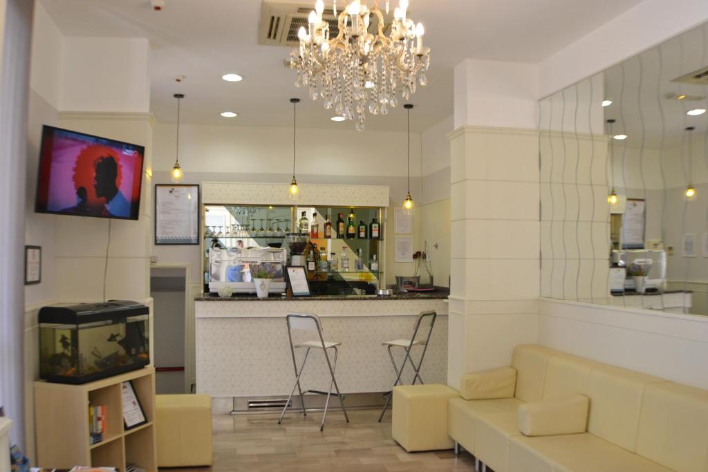 un restaurant avec un bar doté de chaises et d'un lustre dans l'établissement Hotel Villa Caterina, à Rimini