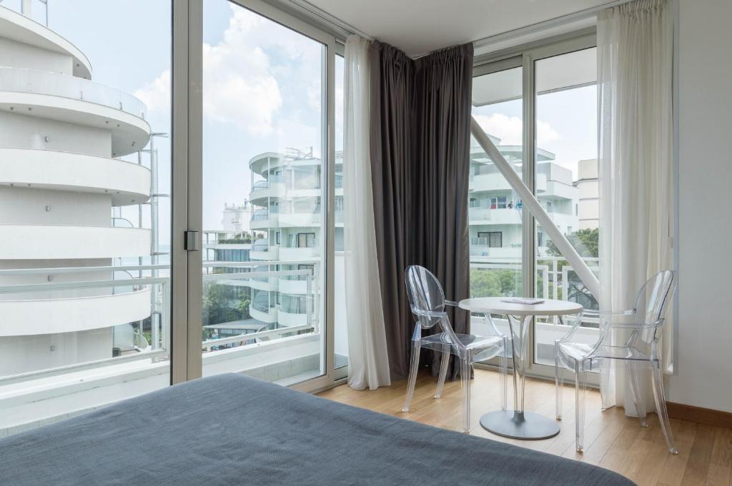 - une chambre avec une grande fenêtre, une table et des chaises dans l'établissement Perla Verde Hotel, à Milano Marittima