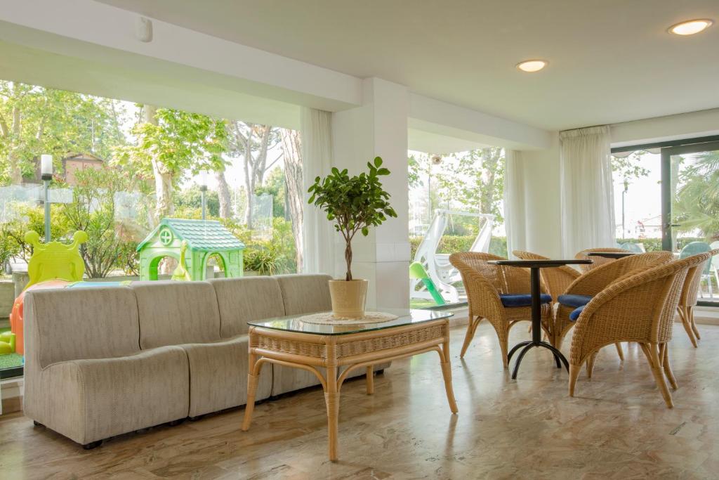 un salon avec un canapé, une table et des chaises dans l'établissement Hotel Baltic, à Cesenatico