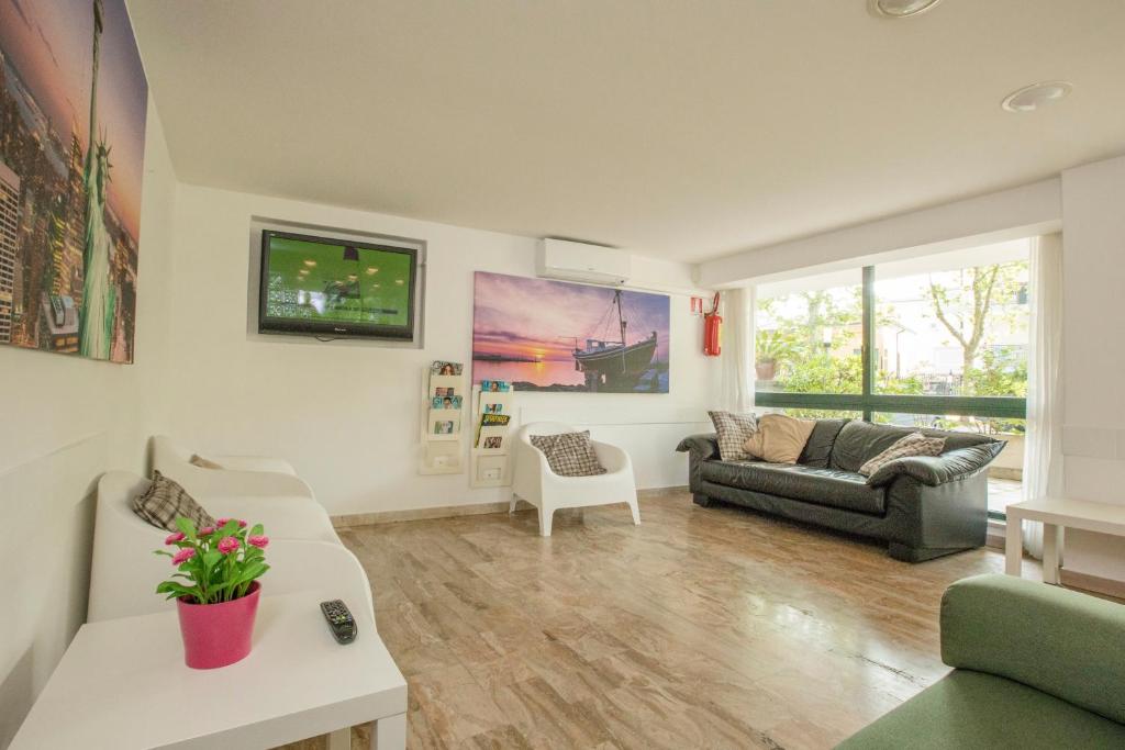 un salon avec un canapé et une télévision dans l'établissement Hotel Baltic, à Cesenatico