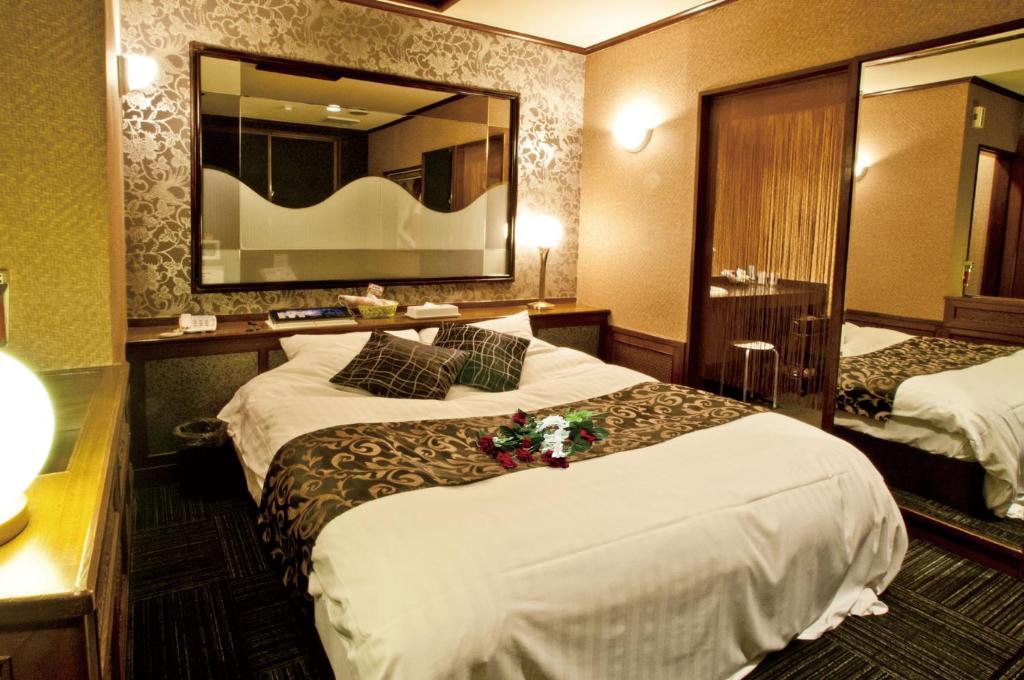 une chambre d'hôtel avec deux lits et un miroir dans l'établissement Hotel Hanabi (Love Hotel), à Chikugo