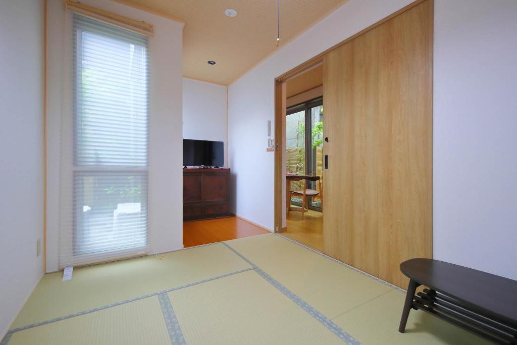 - un salon avec une porte coulissante et une télévision dans l'établissement Kyo Machiya Ryokan Yuan, à Kyoto