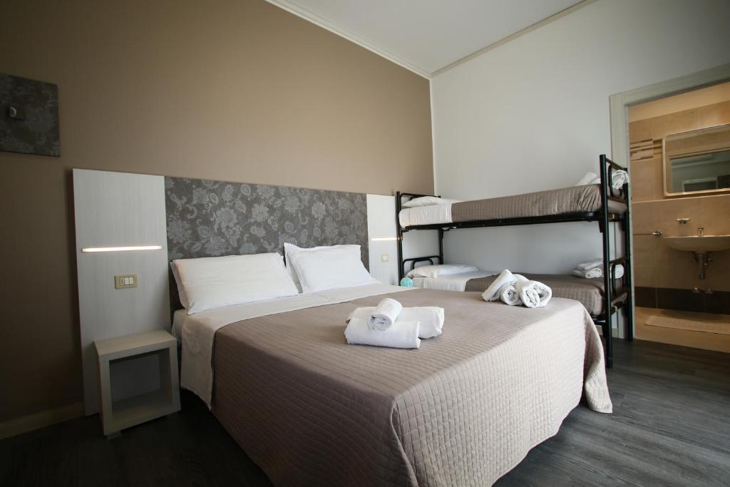 - une chambre avec 2 lits et des serviettes sur le lit dans l'établissement Hotel Kim, à Rimini