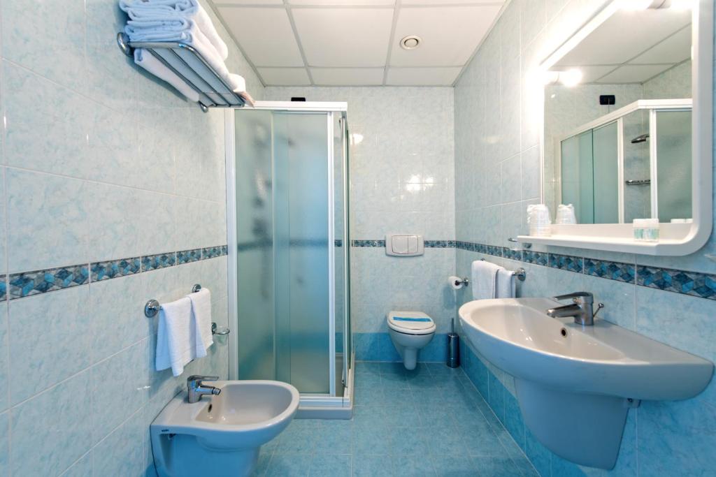 La salle de bains est pourvue de 2 lavabos, d'une douche et de toilettes. dans l'établissement Hotel Minerva, à Lignano Sabbiadoro 26 autres photos