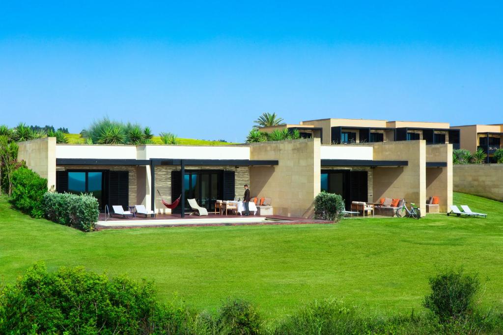 une maison avec une pelouse verte devant dans l'établissement Verdura Resort, à Ribera