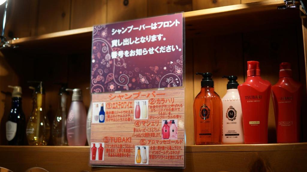 une étagère avec un bouquet de bouteilles d'alcool dans l'établissement Hotel Jupiter (Adult Only), à Hiroshima