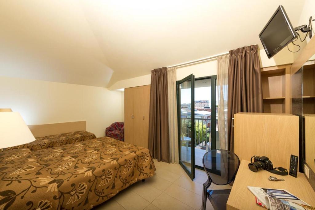 une chambre d'hôtel avec un lit, un bureau et une télévision dans l'établissement Hotel Dei Tigli, à Lido di Camaiore