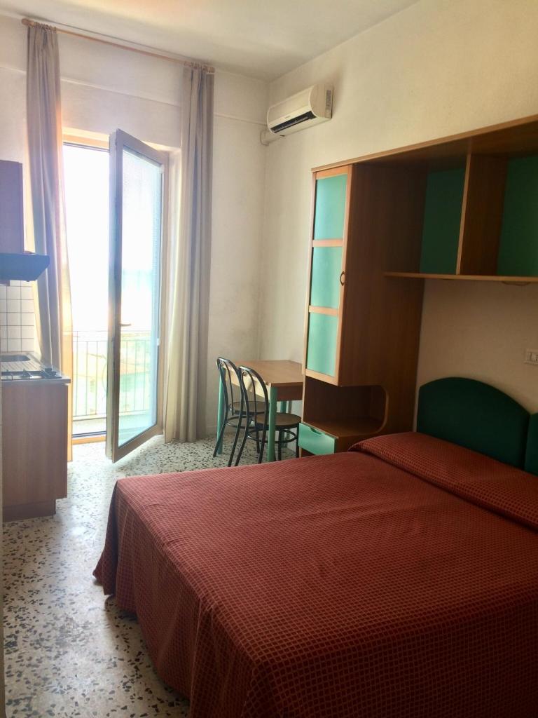 une chambre d'hôtel avec un lit et une table avec des chaises dans l'établissement Residence Ducale, à Rodi Garganico