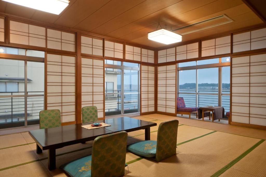 une pièce avec une table, des chaises et des fenêtres dans l'établissement Kohan-no-Yado Morimoto, à Kaga