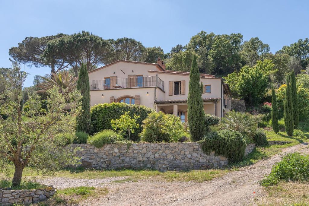une maison sur une colline avec un mur de pierre dans l'établissement Casa Bernardino by VacaVilla, à Campiglia Marittima