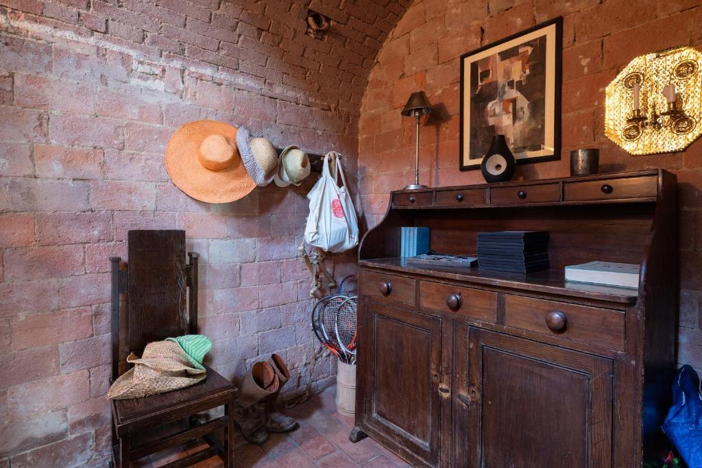 Cette chambre dispose d'une commode en bois et d'un mur en briques. dans l'établissement Casa Bernardino by VacaVilla, à Campiglia Marittima 48 autres photos