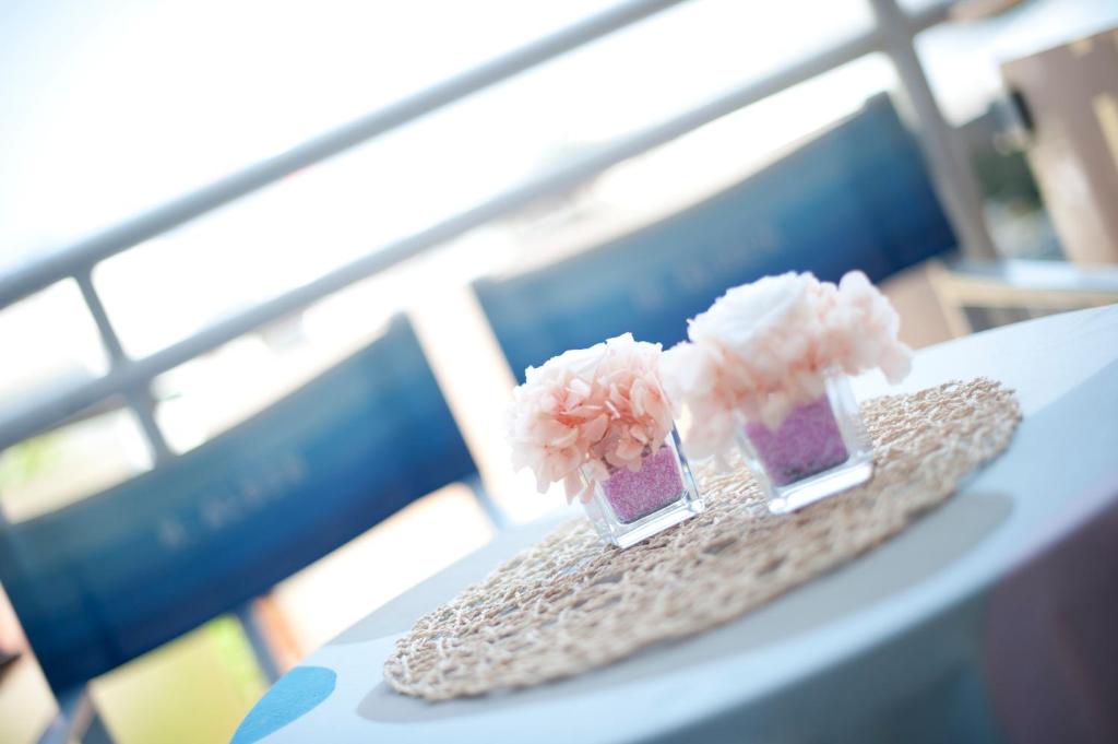 deux petits vases avec des fleurs roses sur une table dans l'établissement Hotel Alsen, à Rimini 35 autres photos