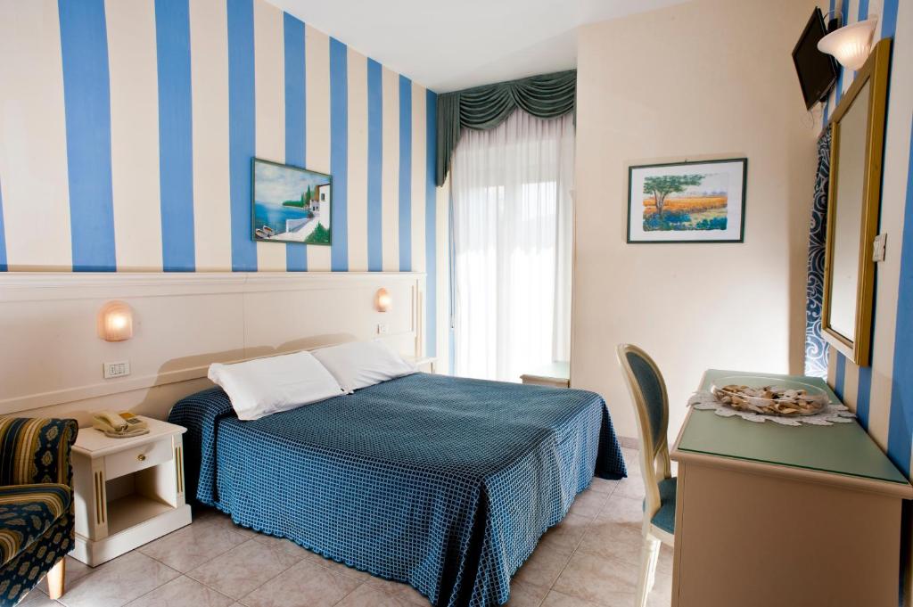 une chambre avec un mur rayé bleu et blanc dans l'établissement Hotel Alsen, à Rimini