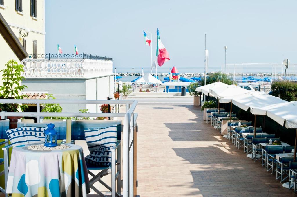 une rangée de tables et de chaises sur une terrasse dans l'établissement Hotel Alsen, à Rimini