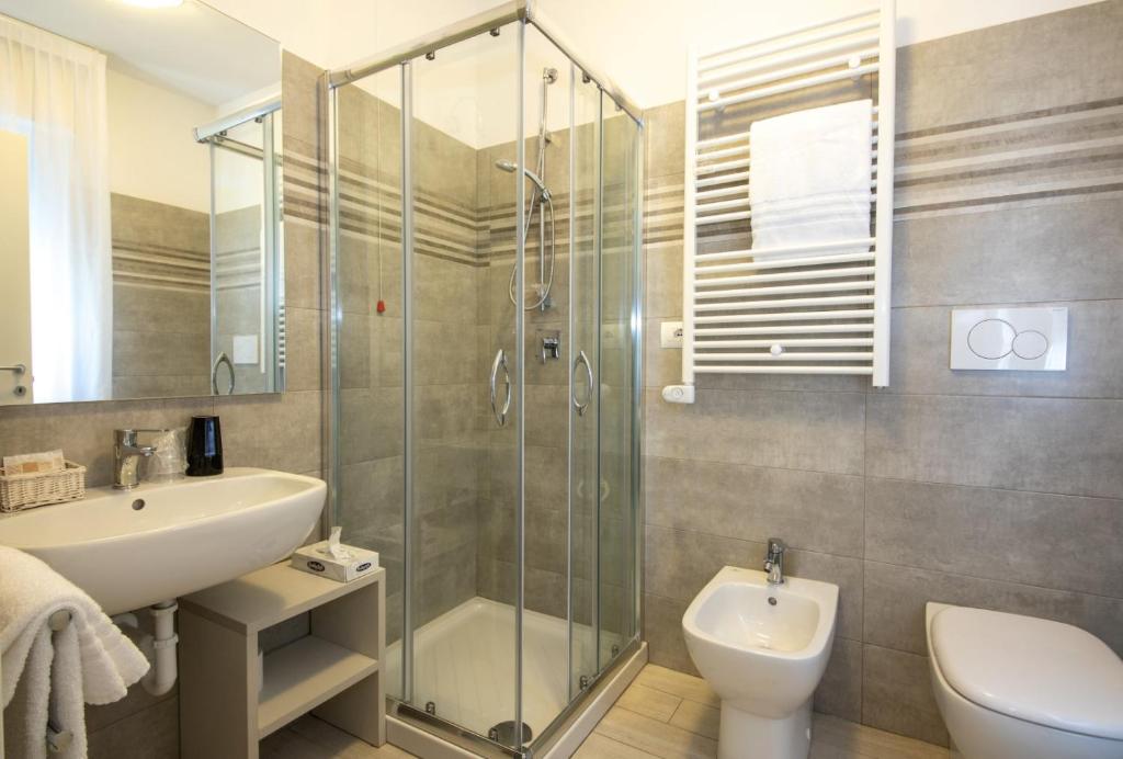 une salle de bain avec douche, lavabo et toilettes dans l'établissement Hotel Plaza Esplanade, à Lido di Jesolo