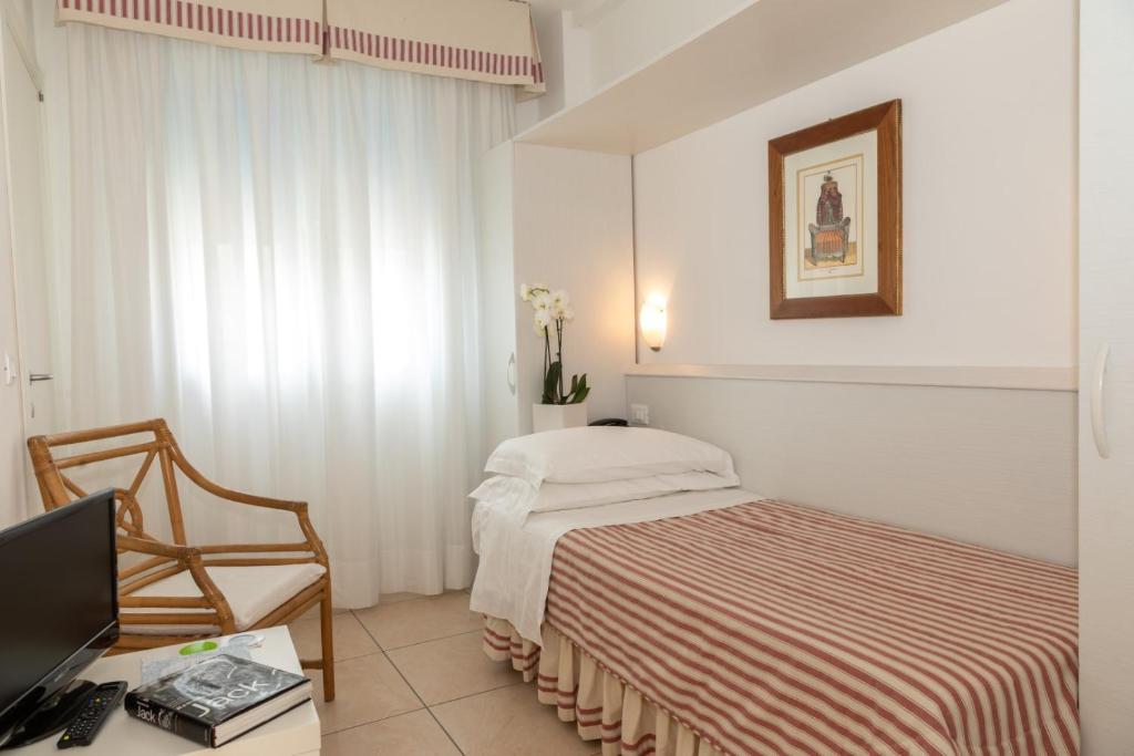 une chambre avec un lit et un bureau avec un ordinateur dans l'établissement Hotel Plaza Esplanade, à Lido di Jesolo