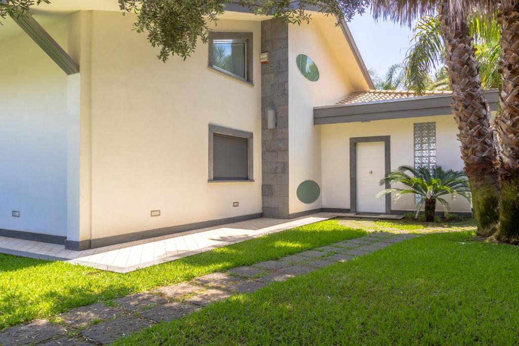 une maison avec une pelouse devant dans l'établissement Villa Oras, à Mascali