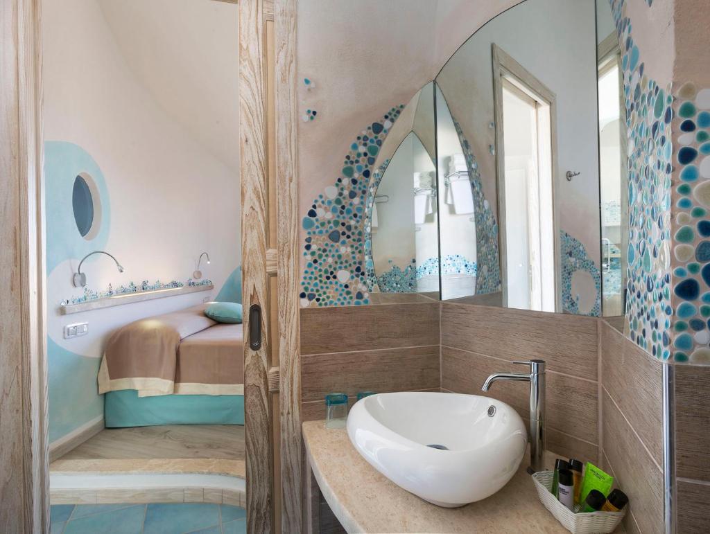 une salle de bain avec un lavabo et un miroir dans l'établissement Hotel Corallaro, à Santa Teresa Gallura