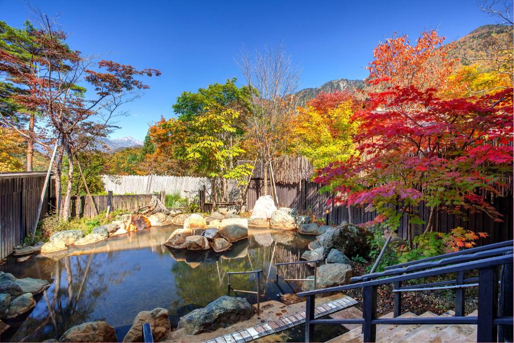 un jardin avec un étang planté de rochers et d'arbres dans l'établissement Miyama Ouan Kyoritsu Resort, à Takayama 37 autres photos