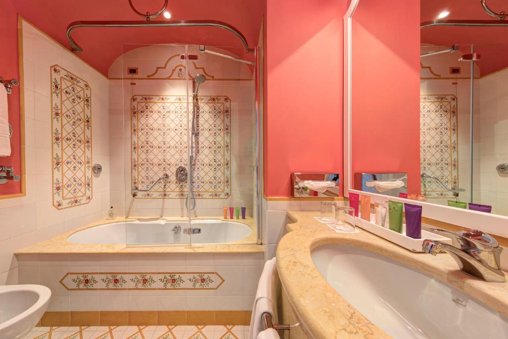 une salle de bains avec baignoire et lavabo dans l'établissement Grand Hotel Royal, à Sorrente