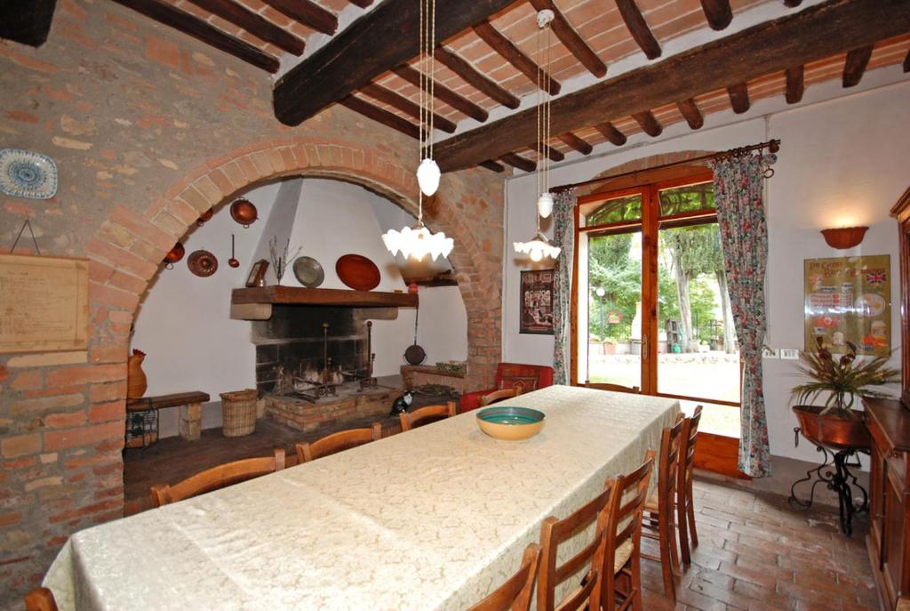 une cuisine avec une table et des chaises ainsi qu'une cheminée dans l'établissement Villa Remignoli, à San Gimignano