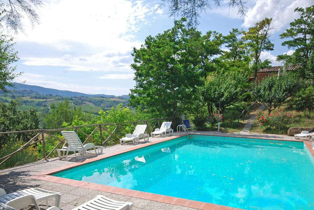 - une piscine avec des chaises et une vue sur les montagnes dans l'établissement Villa Remignoli, à San Gimignano
