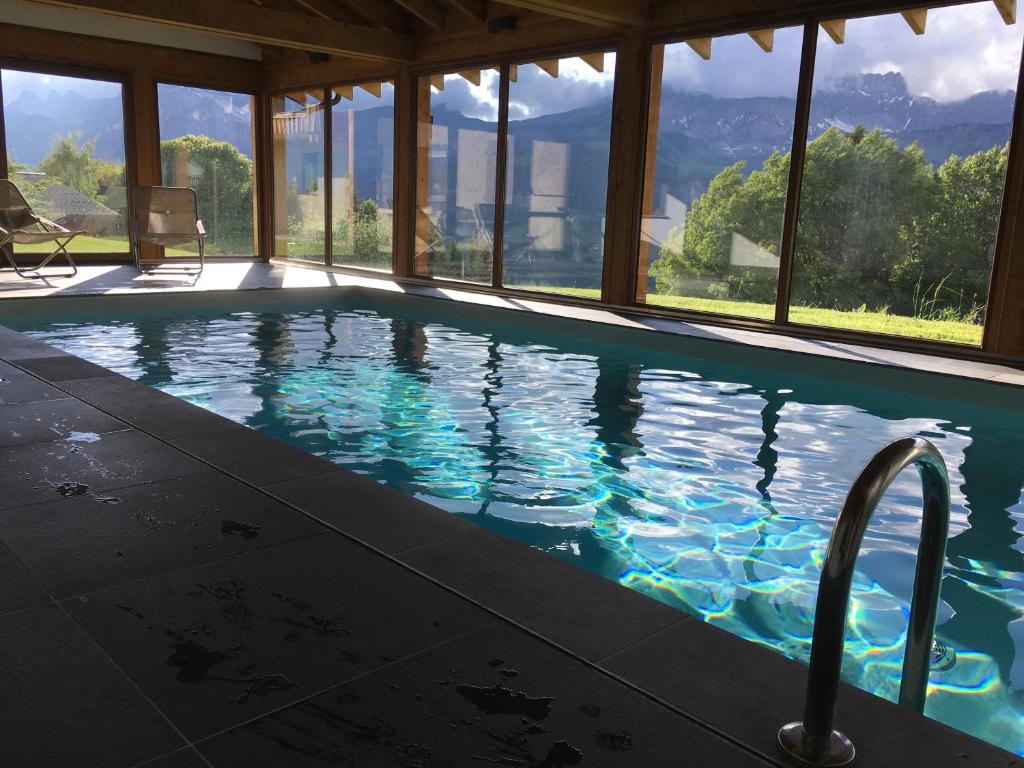 une piscine avec vue sur les montagnes dans l'établissement Le Caprice Des Neiges, à Crest-Voland
