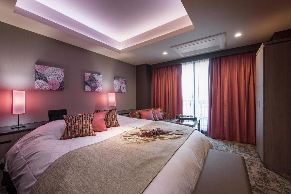 une chambre avec un grand lit dans une pièce dans l'établissement HOTEL C. KOKURA-BAY (Love Hotel), à Kitakyūshū
