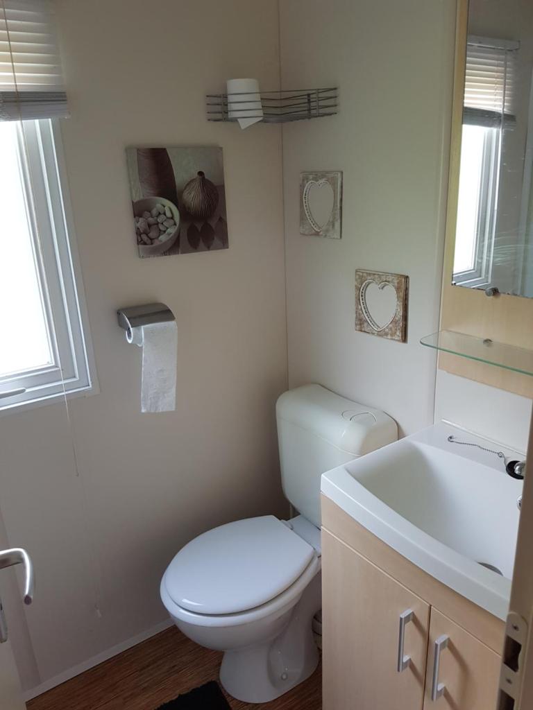 une salle de bain avec des toilettes blanches et un lavabo dans l'établissement Irm hacienda, à Onzain