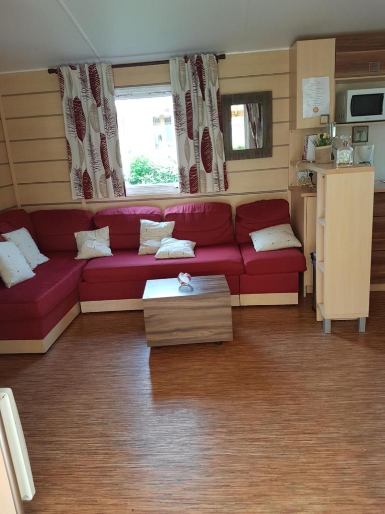 - un salon avec un canapé rouge dans une caravane dans l'établissement Irm hacienda, à Onzain