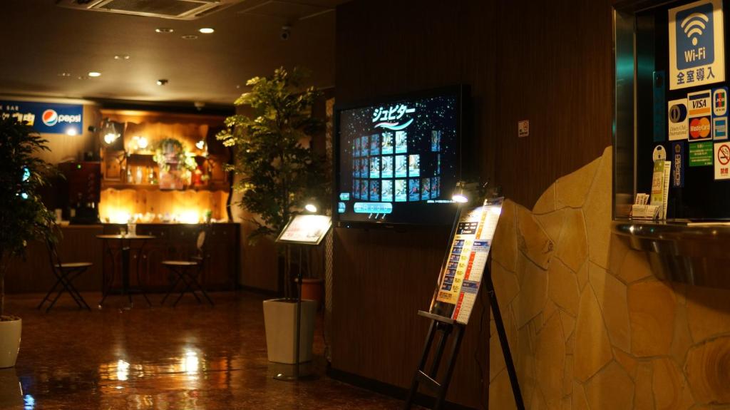 un restaurant avec un bar et un panneau devant lui dans l'établissement Hotel Jupiter (Adult Only), à Hiroshima 5 autres photos