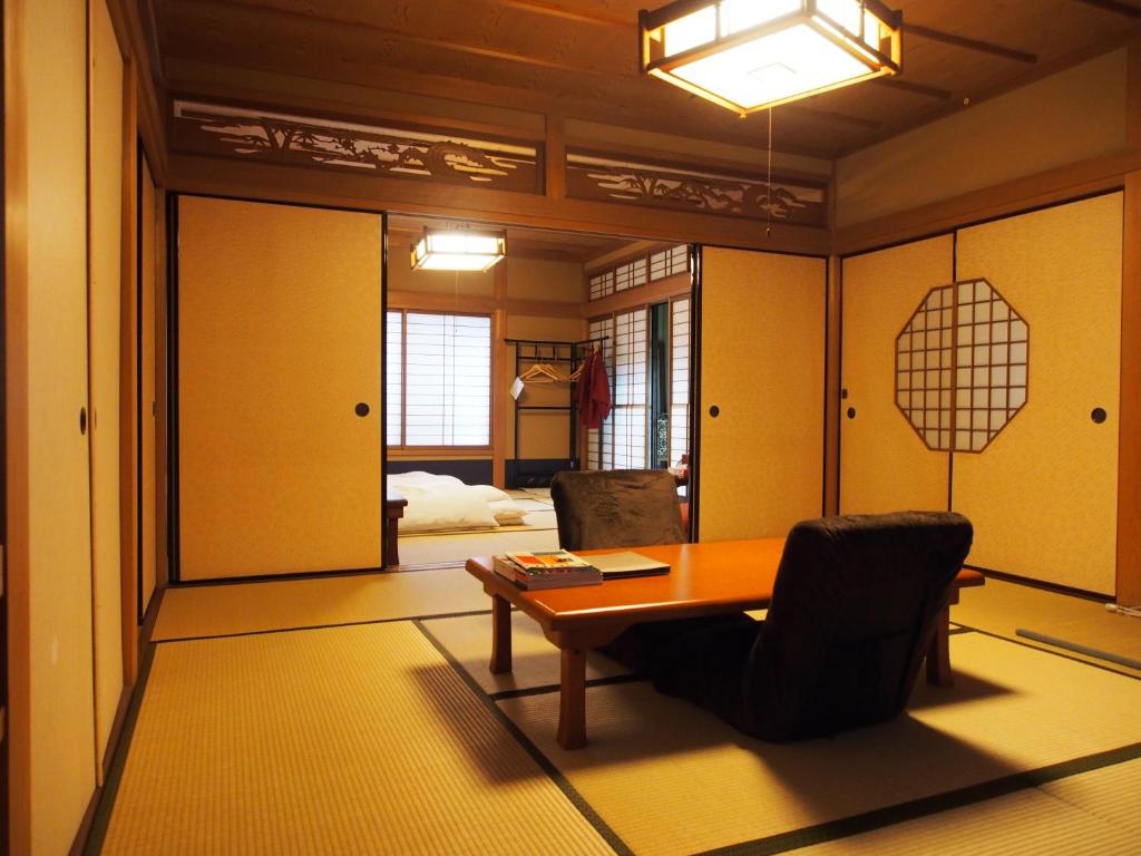 une pièce avec une table et des chaises et une chambre dans l'établissement Kamuroan, à Kyoto