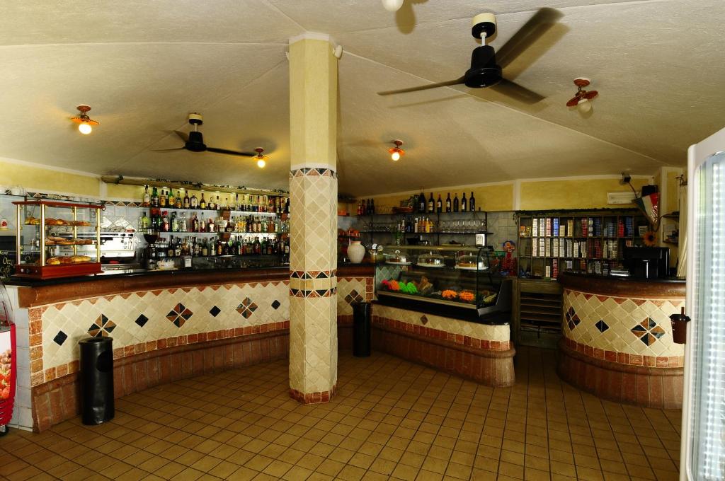 un bar avec une colonne au milieu d'une pièce dans l'établissement Hotel L'Esagono, à San Teodoro