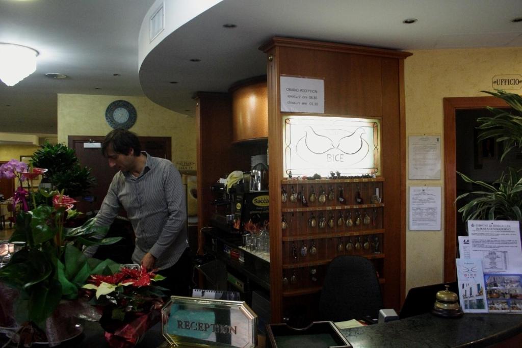 une femme debout dans un magasin avec une exposition de fleurs dans l'établissement Albergo Bice, à Senigallia