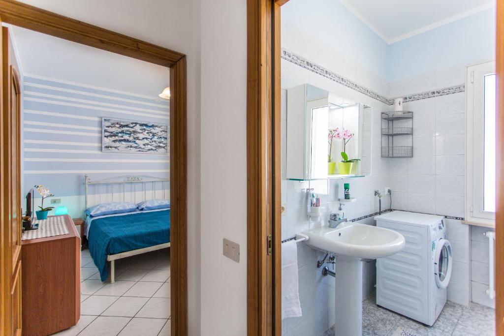 une salle de bain avec un lavabo et des toilettes et un lit dans l'établissement Residence Kimba, à Rimini