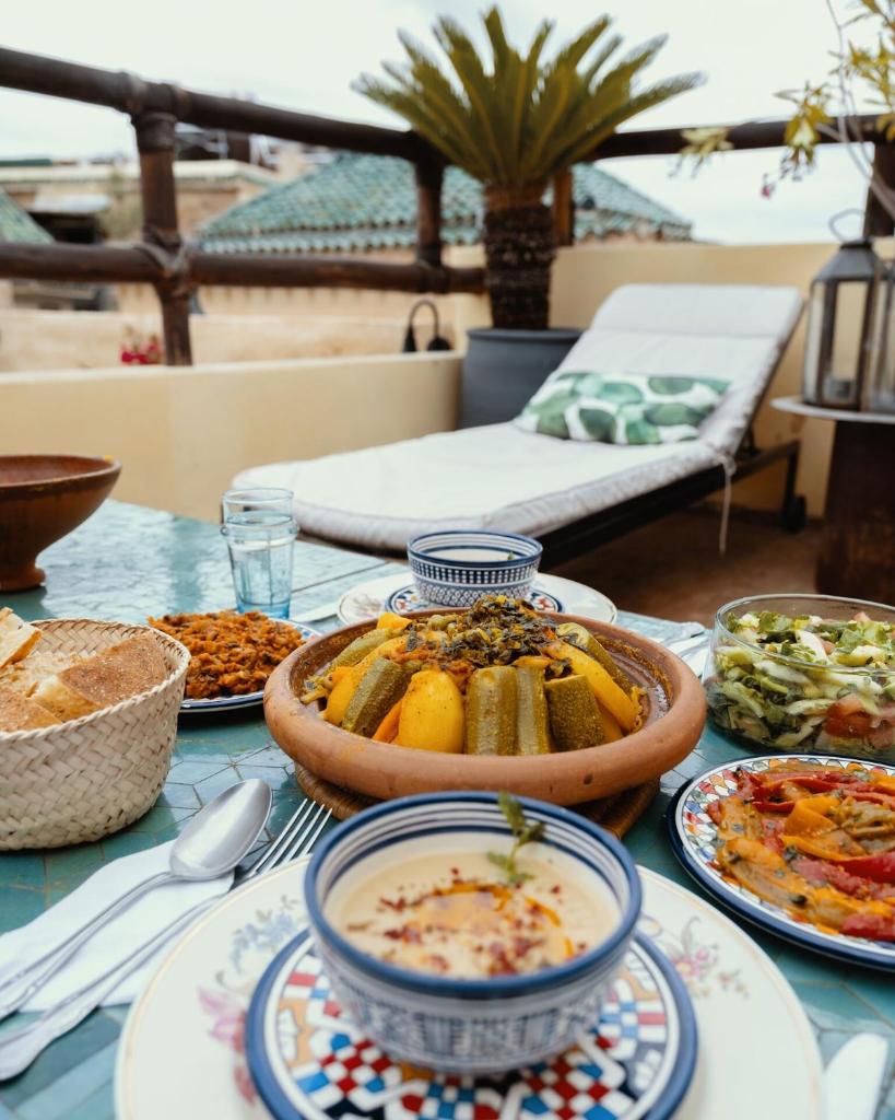 une table avec des assiettes de nourriture sur une table dans l'établissement Riad Anata, à Fès