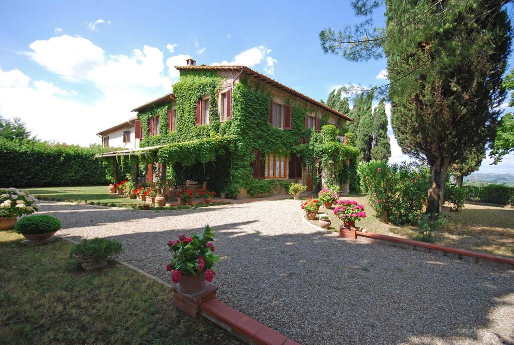 une maison avec du lierre poussant sur le côté dans l'établissement Villa Remignoli, à San Gimignano