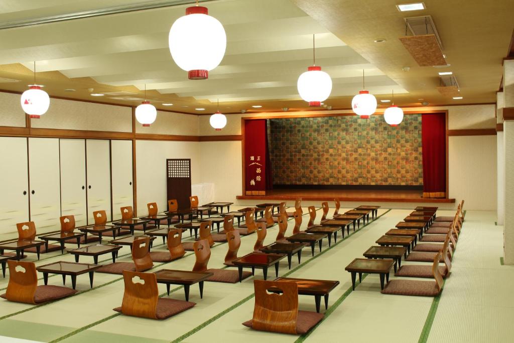 une salle de conférences avec des rangées de chaises et un écran dans l'établissement Miyajima Seaside Hotel, à Miyajima 37 autres photos