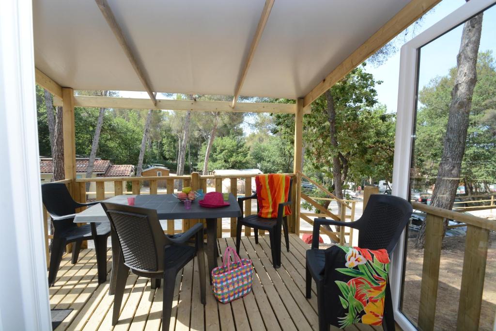 un patio avec une table et des chaises sur une terrasse dans l'établissement Camping les Playes, à Six-Fours-les-Plages